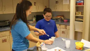 teacher helping a child with special education transition life skills activity - Watson Institute