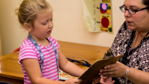 special education teacher helping a child with special needs - Watson Institute