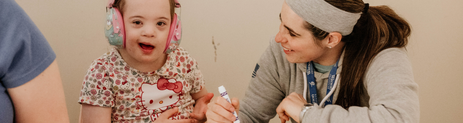 a special education teacher is shown working with her student - Watson Institute