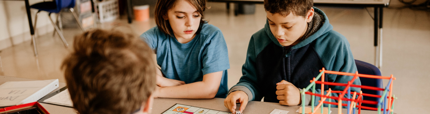 students with autism seated in their classroom playing a game together