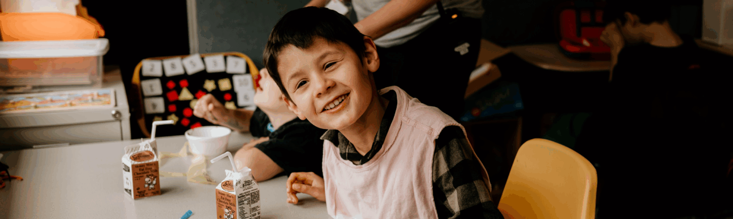 young boy with special needs eating lunch in his classroom at the Watson Institute
