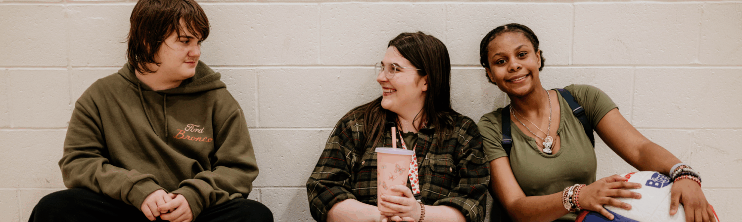 Friendship Academy special education teacher laughing with two students - Watson Institute