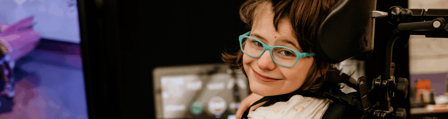young student with physical disabilities smiling in her classroom - Watson Institute