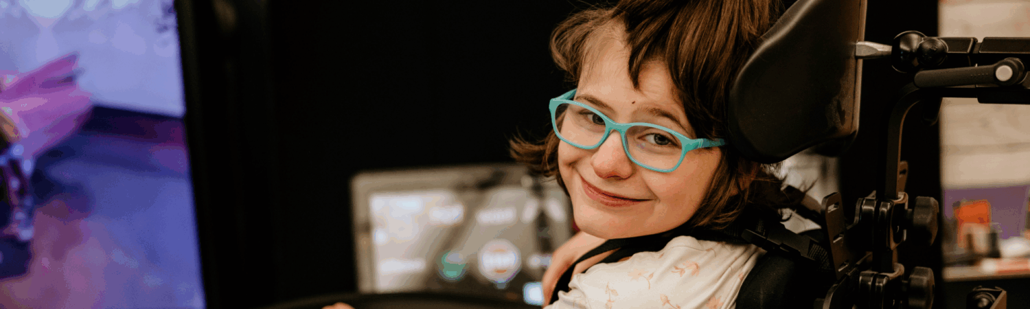 young student with physical disabilities smiling in her classroom - Watson Institute