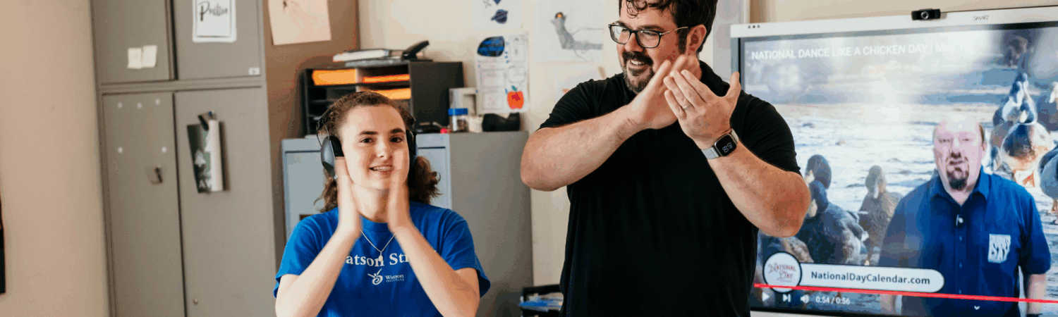 special education teacher clapping and dancing with student with disabilities - Watson Institute
