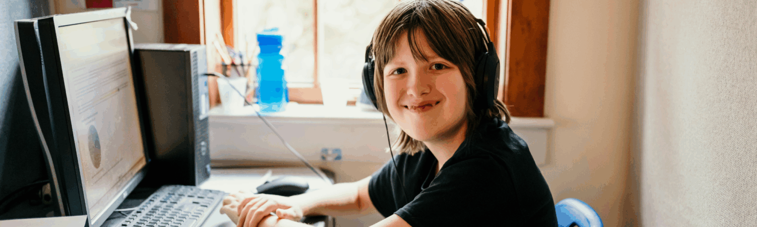 young autistic student sitting at his desk in the WISCA classroom - Watson Institute