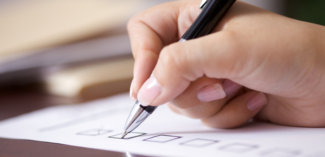 a hand is pictured checking things off of a positive behavior support plan checklist - Watson Institute