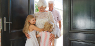 children welcoming their grandparents visiting their home - Watson Institute