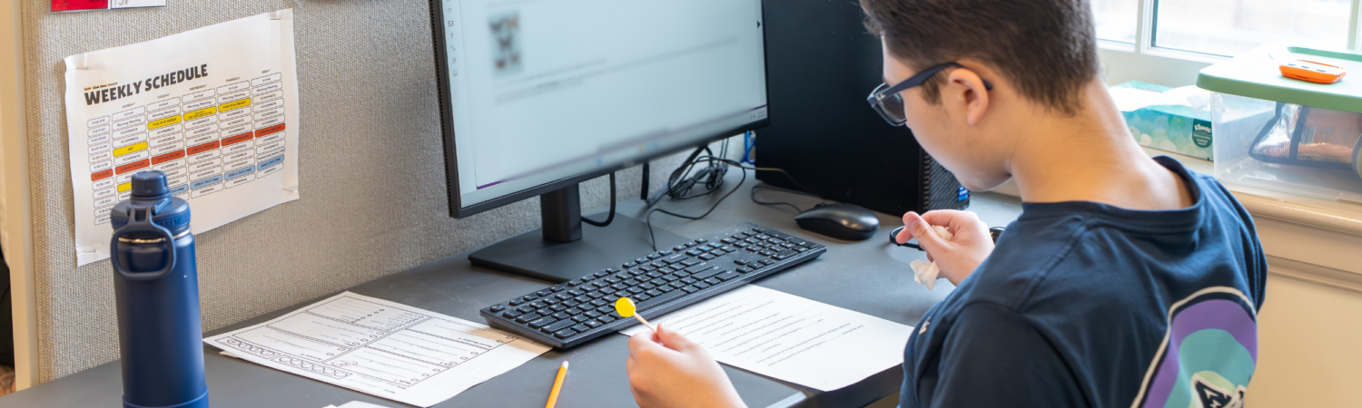 a student with autism works through classroom assignments on the computer in the WISCA school program - Watson Institute