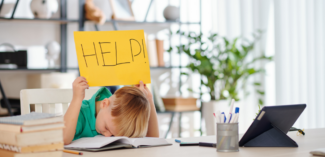 a student holds up a response card to indicate that they need more help understanding a lesson - Watson Institute