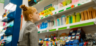 student looking at school supplies available in the school store, a strategy to improve peer social skills and interactions - Watson Institute
