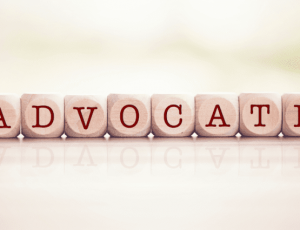 Letters pictured on dice that spell out Advocate