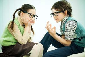 two children sitting facing each other in conversation