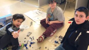 students work together on model engine project in classroom