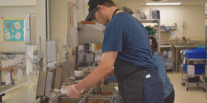Autistic student working in the kitchen at his part-time job.