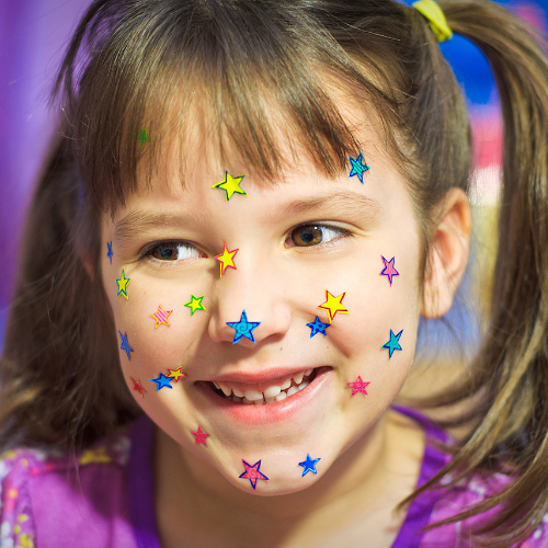 young child pictured with star stickers all over her face - Watson Institute
