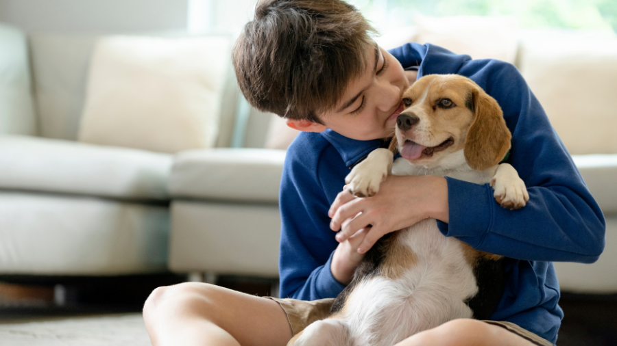 young boy shown cuddling a dog and showing kindness to an animal - Watson Institute