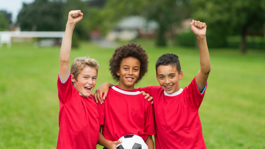 young boys encouraging each other on the soccer field - Watson Institute