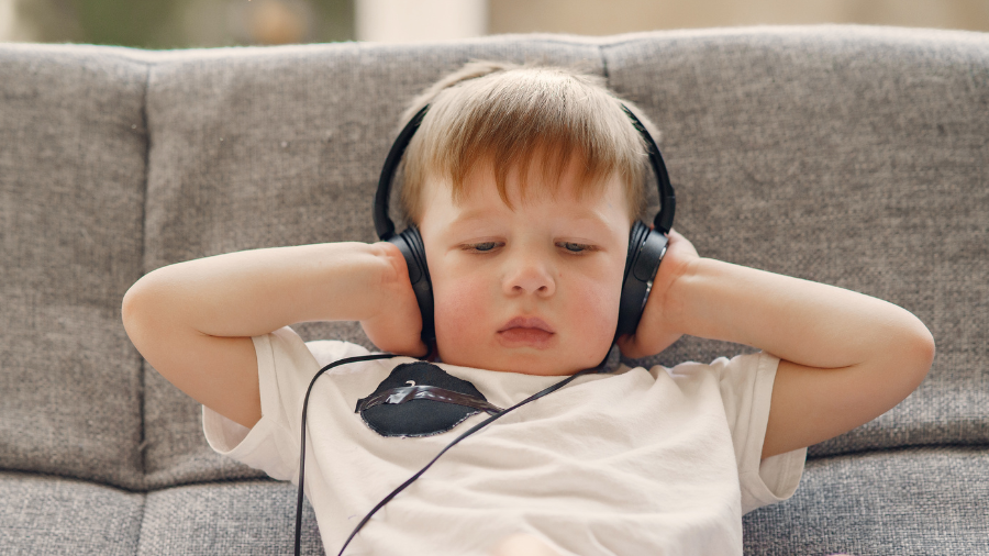 young child wearing headphones and relaxing in a calming space - Watson Institute