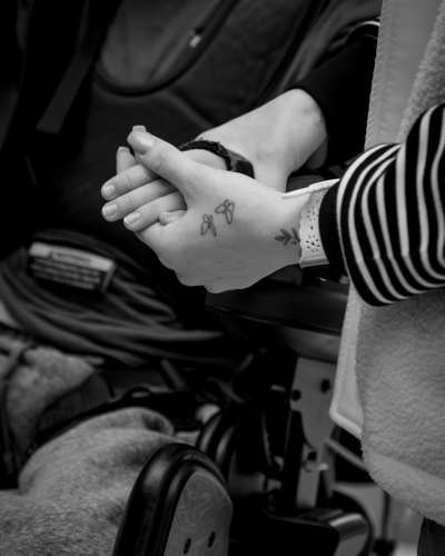 an educator holds the hand of a student with physical disabilities - Watson Institute