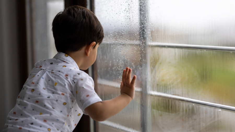 student looking outside at the rain that changed outdoor recess on the schedule to indoor recess - Watson Institute