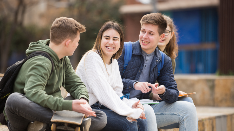 teens engaged in conversation showing happy and relaxed body language and facial expressions - Watson Institute