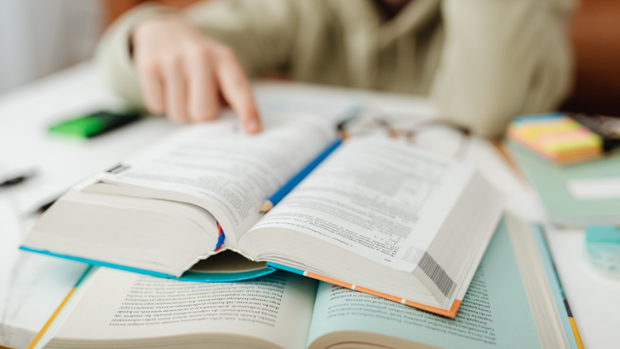 student searching through textbooks to find question answers using the QAR strategy - Watson Institute