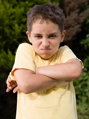 student with arms crossed who may need support with the use of reinforcers, shaping, or structured choice to get them to transition from recess - Watson Institute