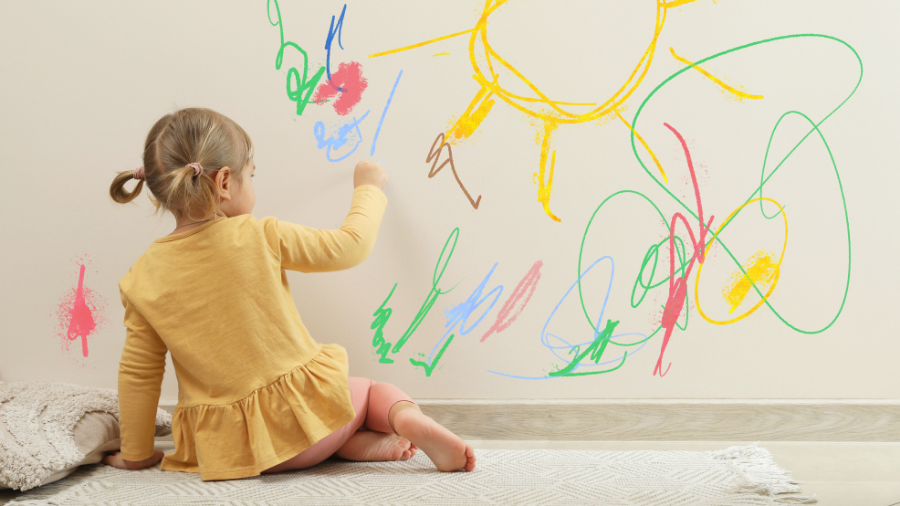 a young child is pictured drawing on walls - Watson Institute