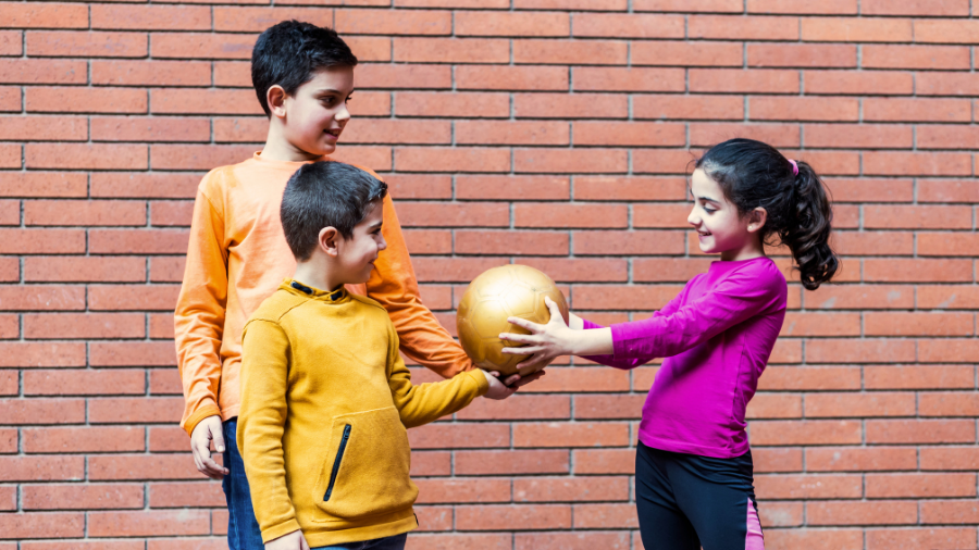 adolescents showing respect to each other when sharing their belongings, holding a soccer ball nicely between them all - Watson Institute