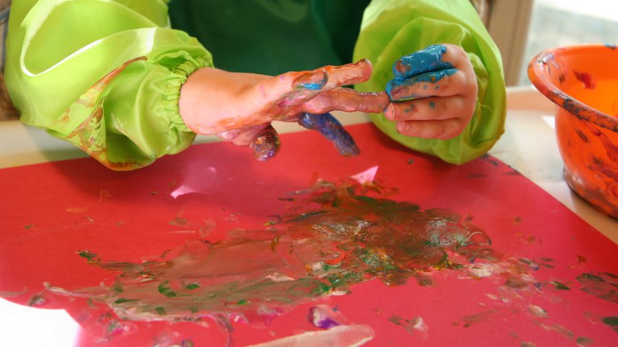 child is fingerpainting but a fellow student may have tactile defensiveness and need solutions to participate in another way - Watson Institute